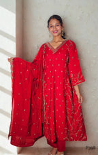 Woman wearing a red traditional outfit with gold embroidery against a neutral background