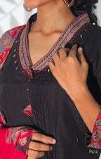 Close-up of a person wearing a black outfit with red and gold embroidery.