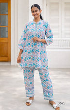 Woman wearing a floral kurta and pants set in a bright room.