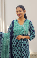 Woman wearing a green and navy patterned outfit with a matching scarf.