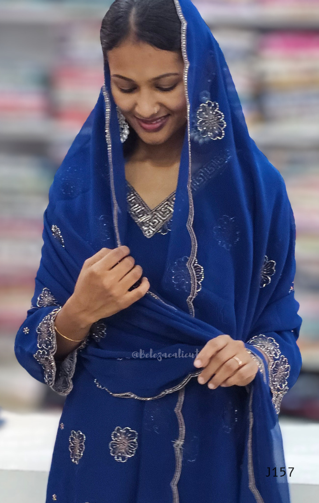 Woman wearing a blue embroidered traditional outfit with a blurred background