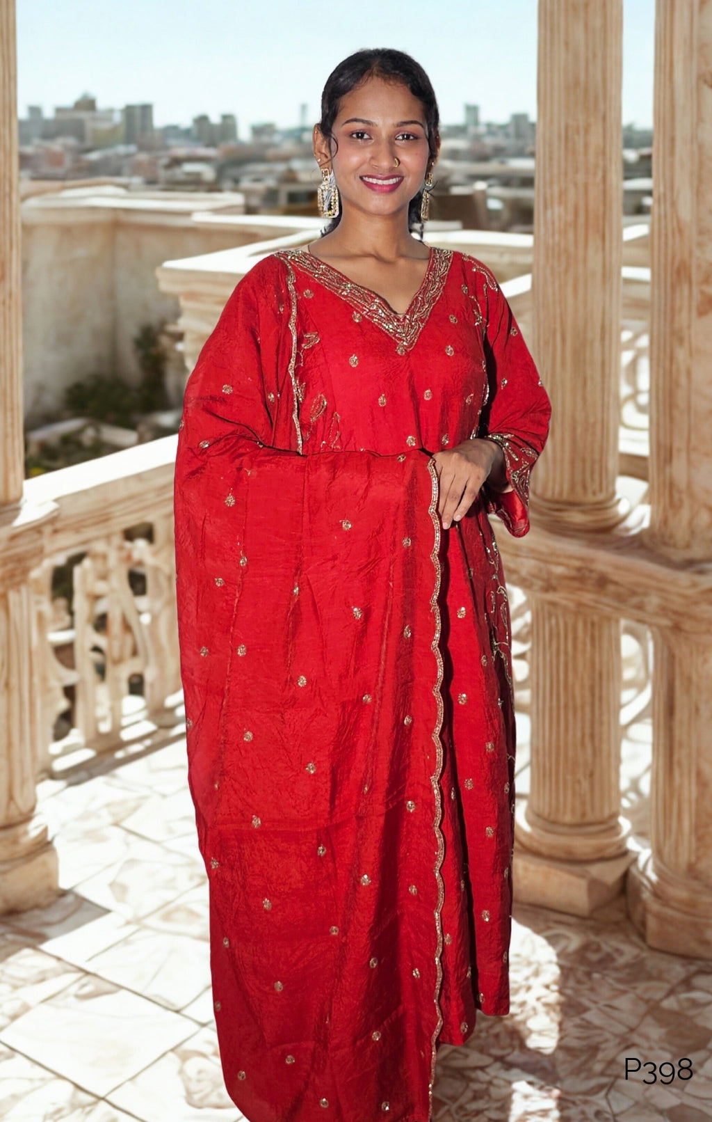 Woman in a red traditional outfit standing on a balcony with a cityscape view.