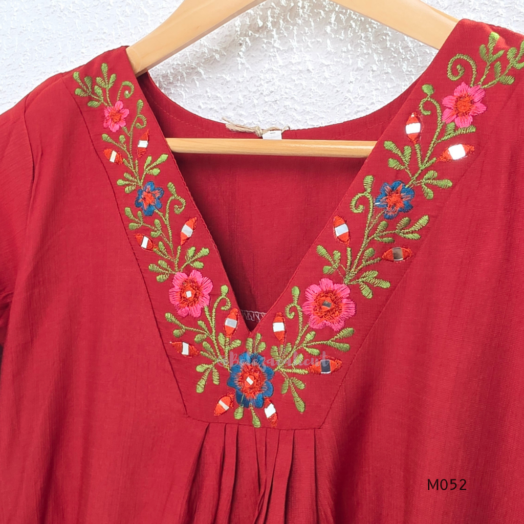 Red embroidered dress on a hanger with floral patterns