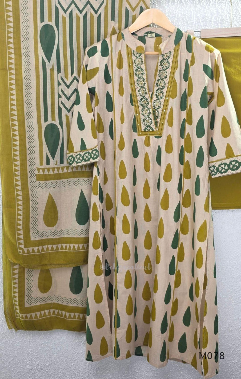 Beige cotton 3-piece churidar set with green and mustard drop motif, embroidered neckline, mustard bottom and printed dupatta.