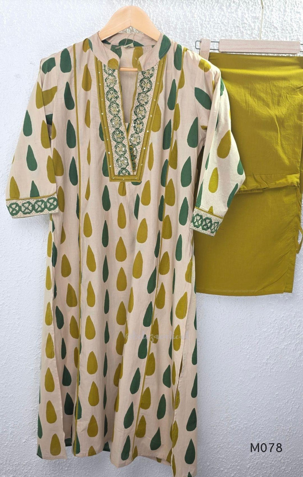 Beige cotton 3-piece churidar set with green and mustard drop motif, embroidered neckline, mustard bottom and printed dupatta.