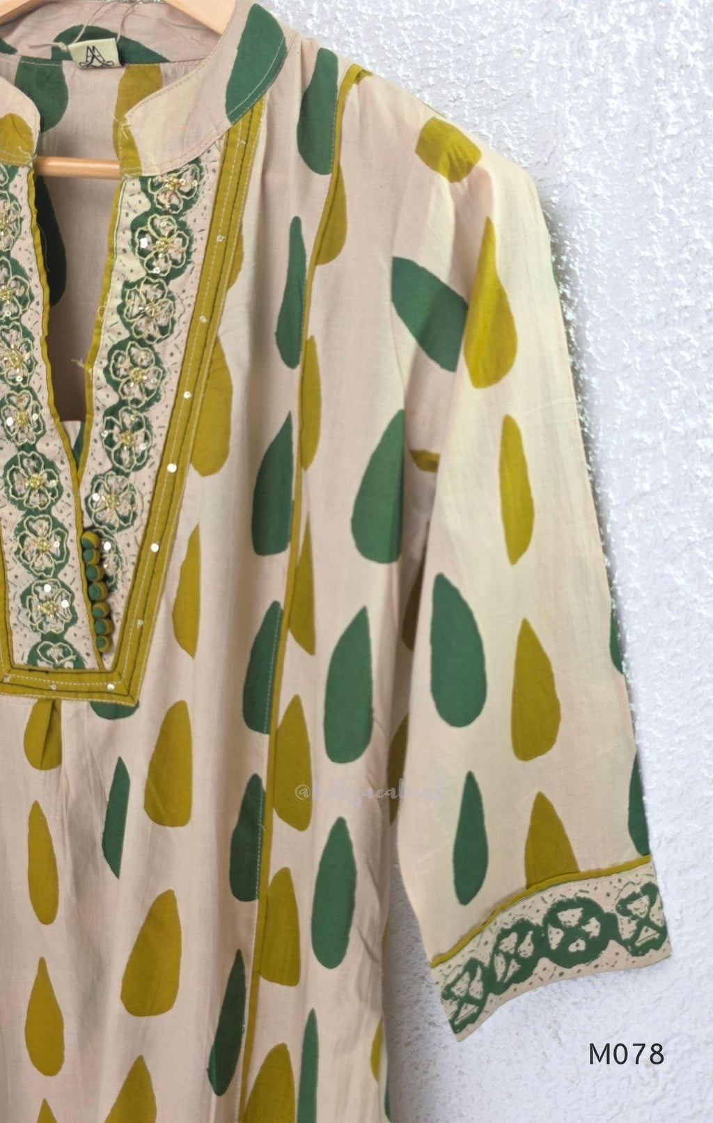 Beige cotton 3-piece churidar set with green and mustard drop motif, embroidered neckline, mustard bottom and printed dupatta.