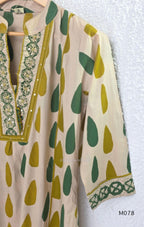 Beige cotton 3-piece churidar set with green and mustard drop motif, embroidered neckline, mustard bottom and printed dupatta.