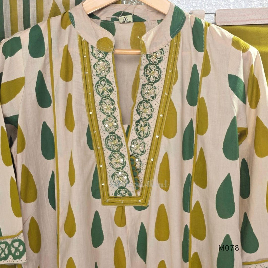 Beige cotton 3-piece churidar set with green and mustard drop motif, embroidered neckline, mustard bottom and printed dupatta.