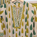 Beige cotton 3-piece churidar set with green and mustard drop motif, embroidered neckline, mustard bottom and printed dupatta.
