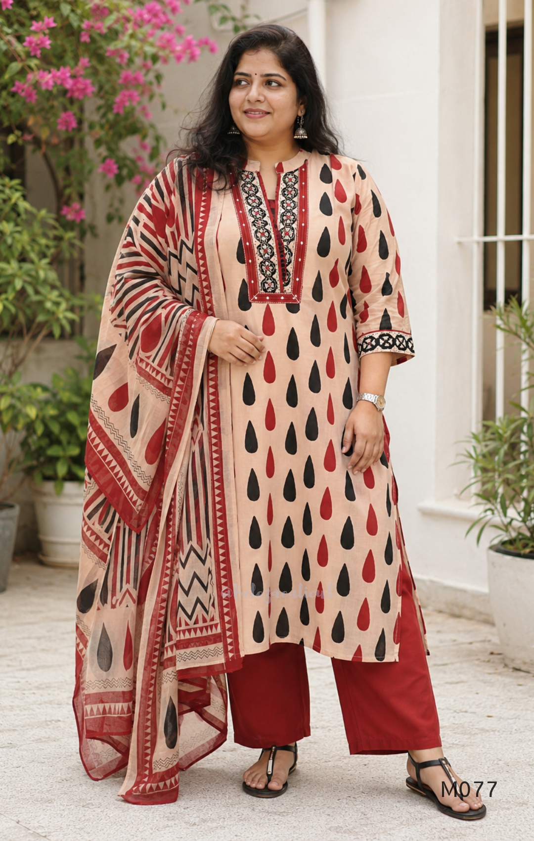 Beige cotton churidar set with red and black teardrop print, embroidered neckline, contrast red bottom and printed dupatta.