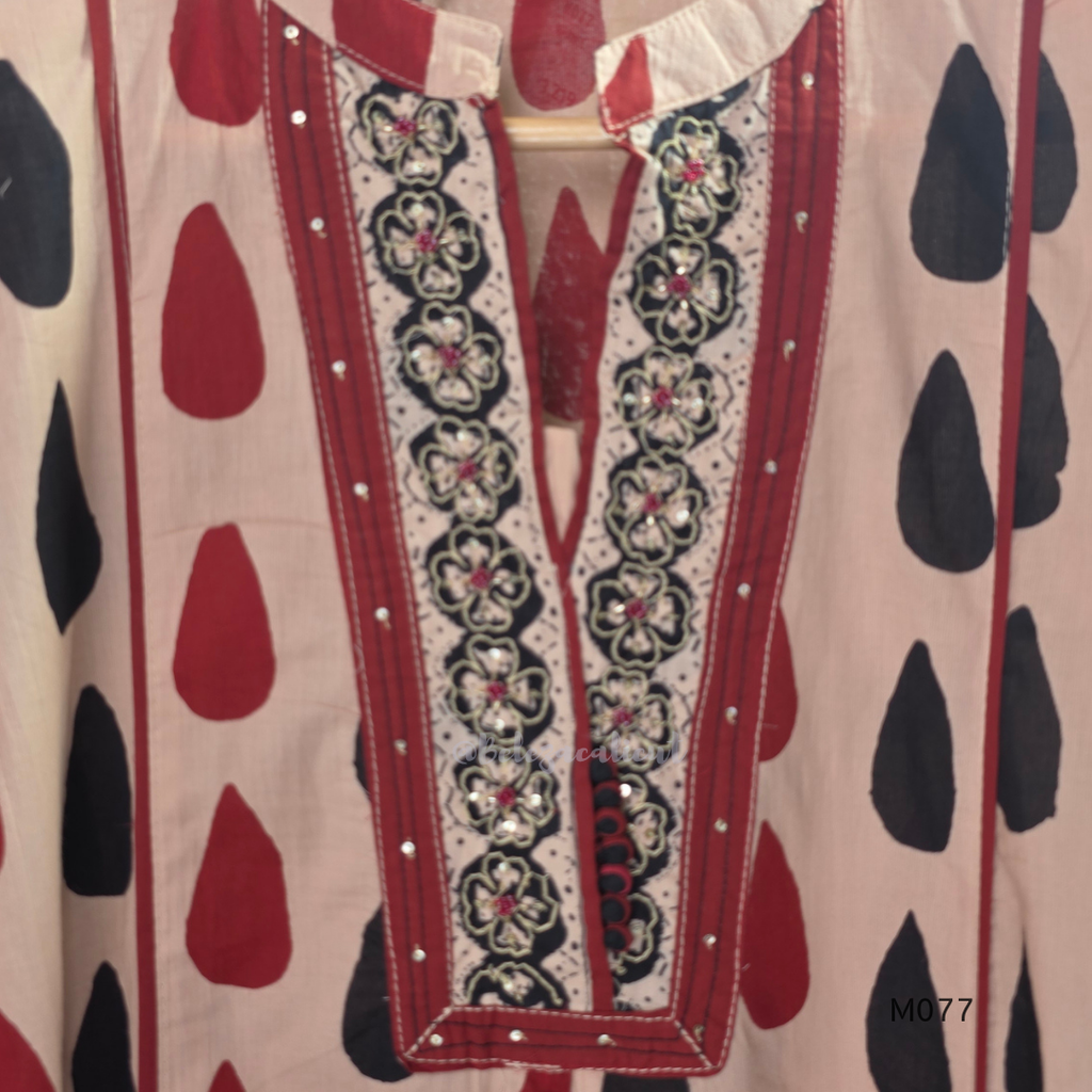 Beige cotton churidar set with red and black teardrop print, embroidered neckline, contrast red bottom and printed dupatta.