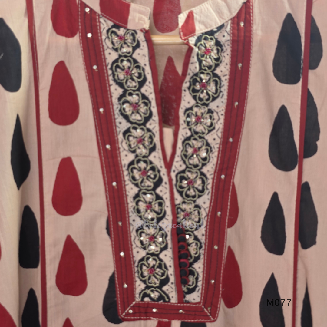 Beige cotton churidar set with red and black teardrop print, embroidered neckline, contrast red bottom and printed dupatta.