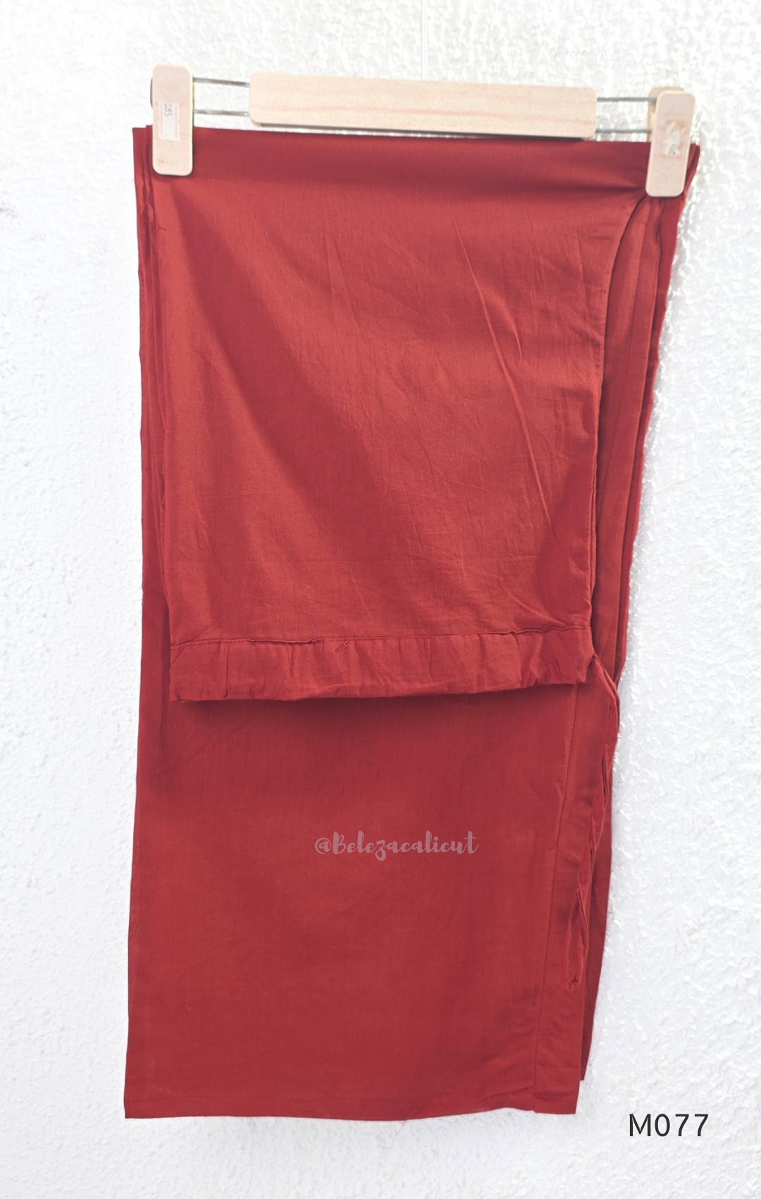 Beige cotton churidar set with red and black teardrop print, embroidered neckline, contrast red bottom and printed dupatta.