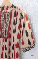 Beige cotton churidar set with red and black teardrop print, embroidered neckline, contrast red bottom and printed dupatta.
