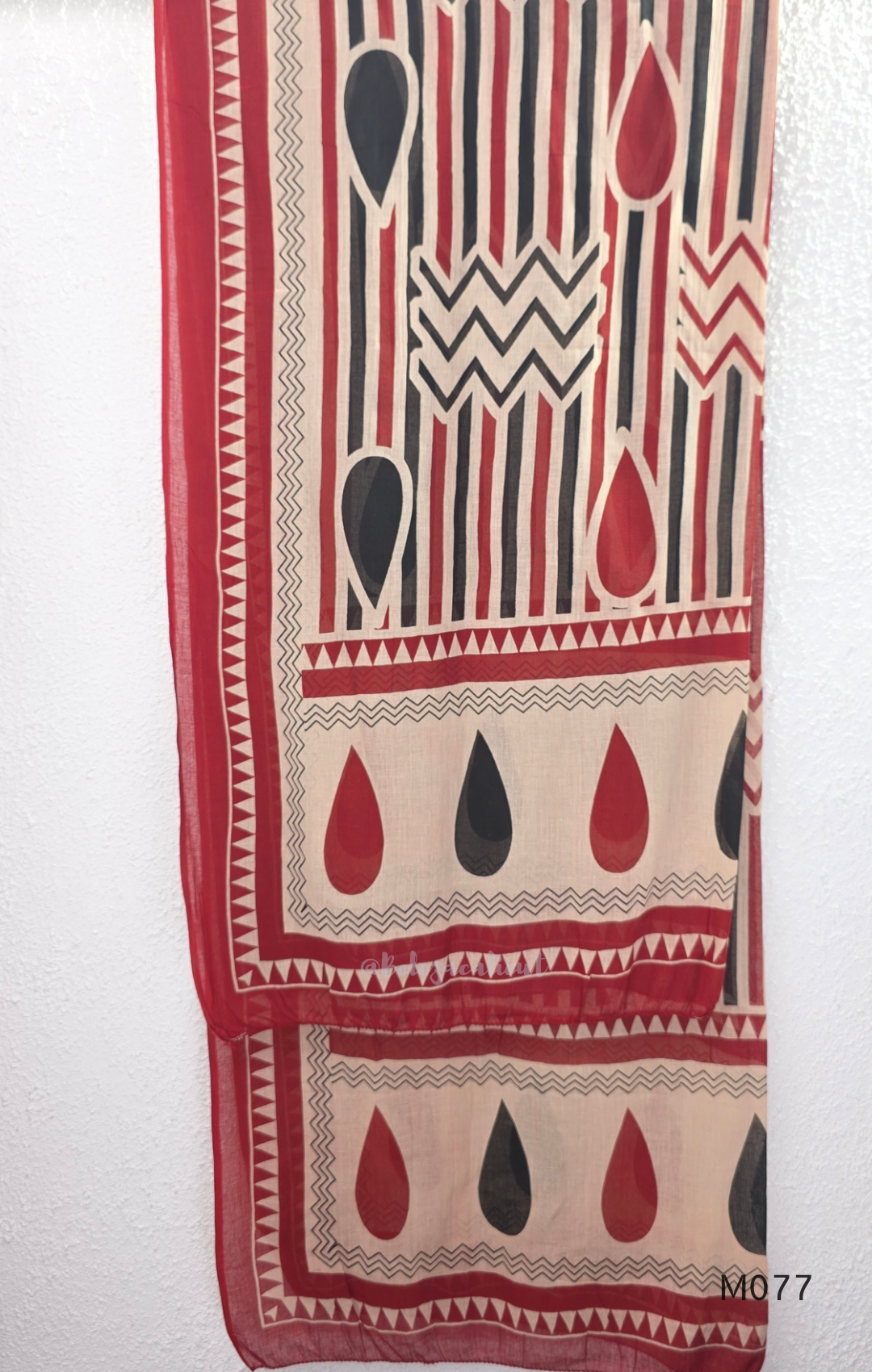 Beige cotton churidar set with red and black teardrop print, embroidered neckline, contrast red bottom and printed dupatta.