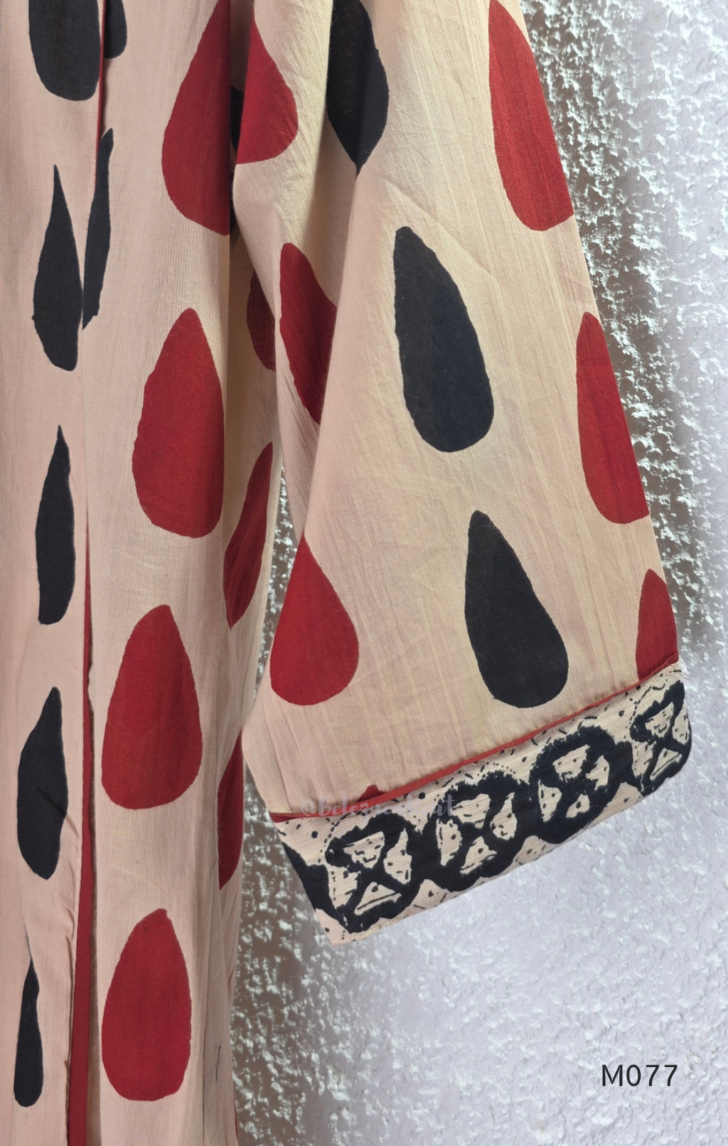 Beige cotton churidar set with red and black teardrop print, embroidered neckline, contrast red bottom and printed dupatta.