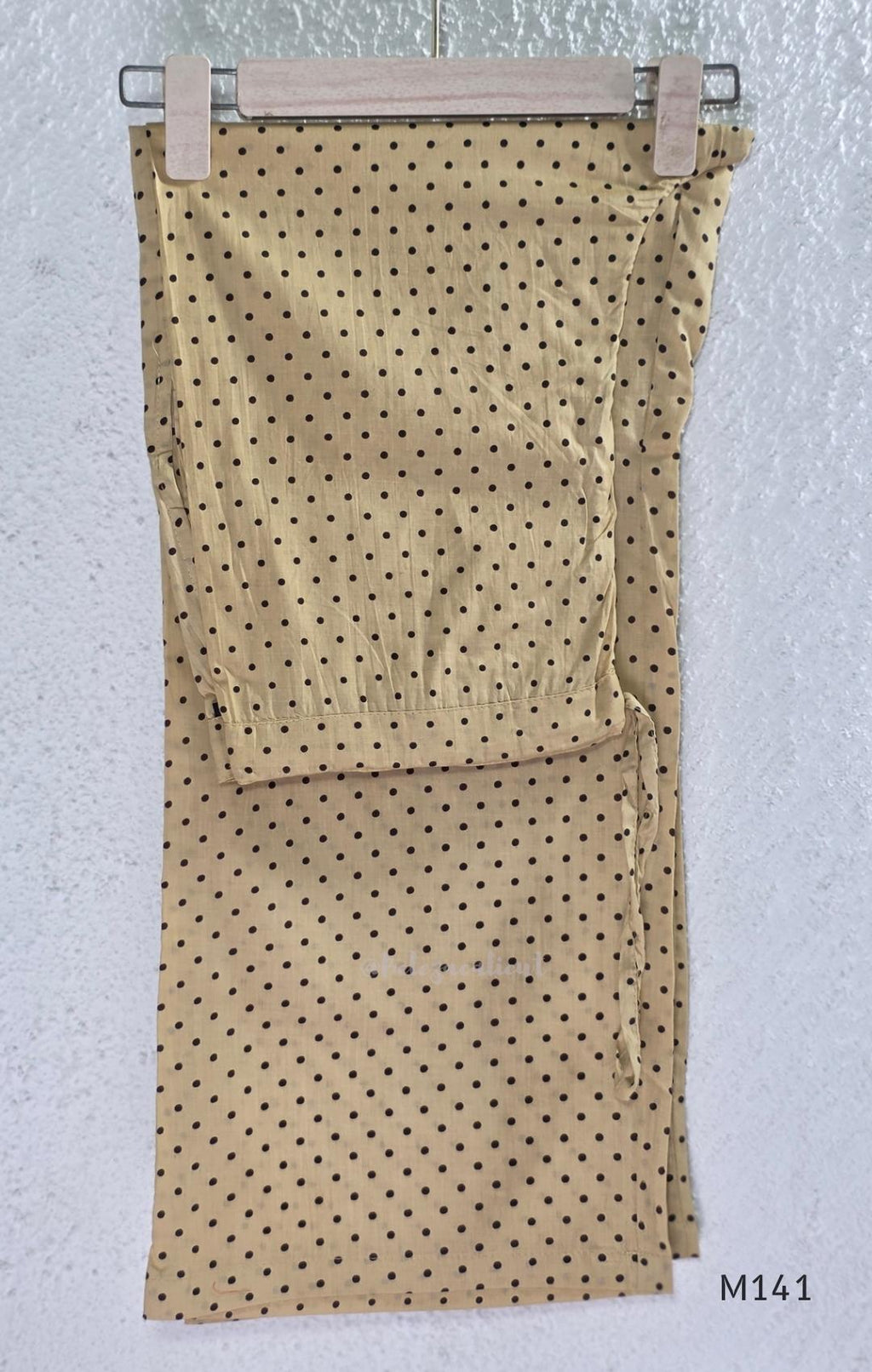 Beige cotton churidar set with dark brown geometric print, red accents, mirror-work yoke, tassels and coordinated dupatta.
