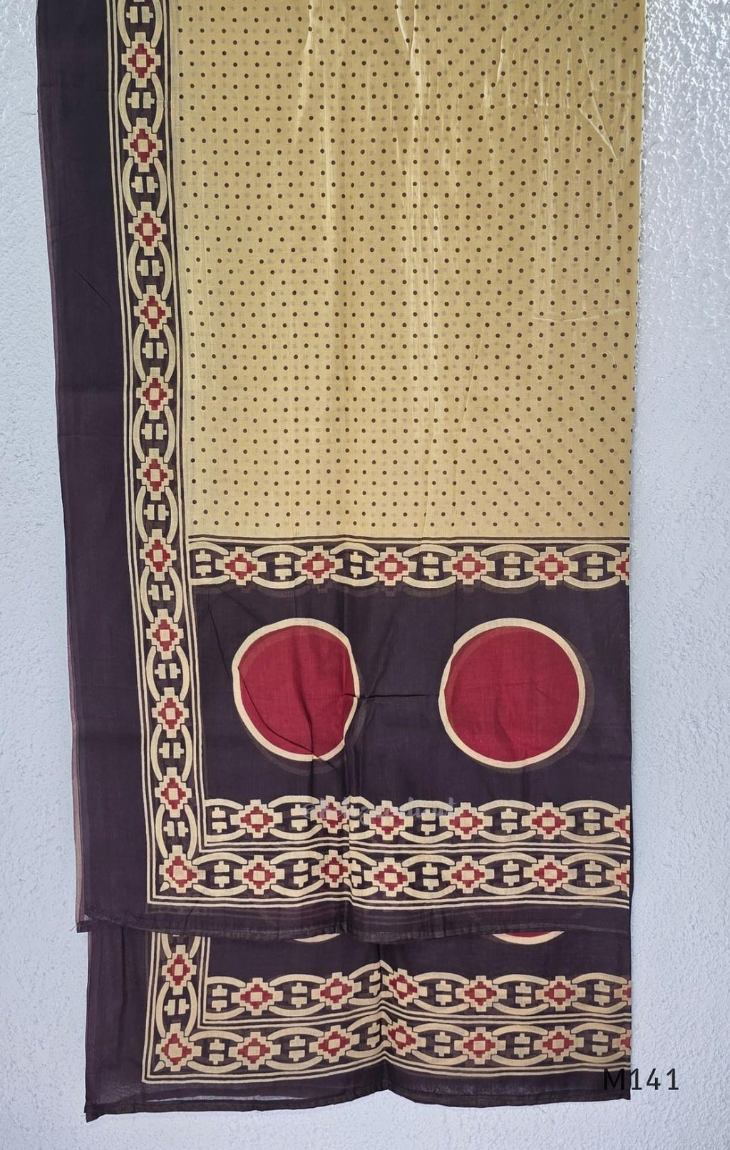 Beige cotton churidar set with dark brown geometric print, red accents, mirror-work yoke, tassels and coordinated dupatta.