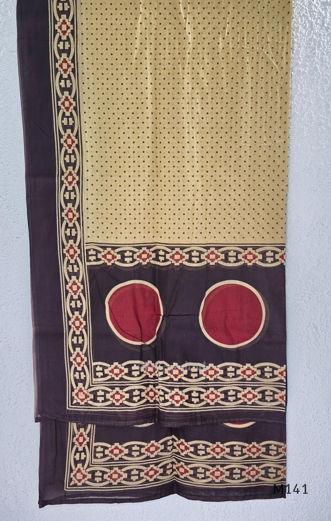 Beige cotton churidar set with dark brown geometric print, red accents, mirror-work yoke, tassels and coordinated dupatta.