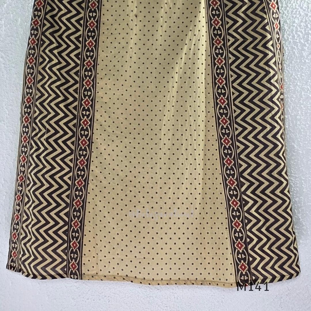 Beige cotton churidar set with dark brown geometric print, red accents, mirror-work yoke, tassels and coordinated dupatta.