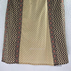 Beige cotton churidar set with dark brown geometric print, red accents, mirror-work yoke, tassels and coordinated dupatta.