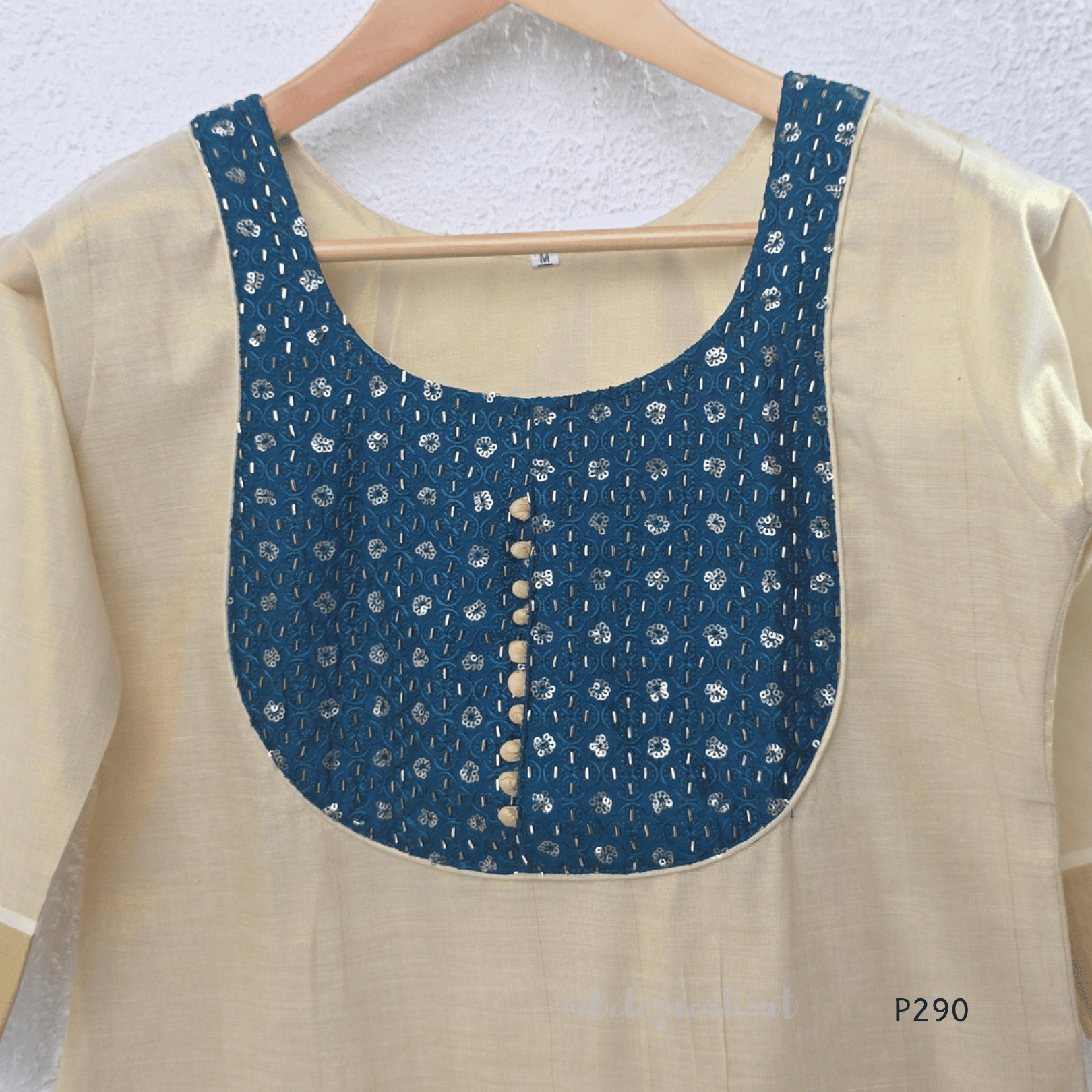 Beige cotton women’s ethnic top with teal embroidered yoke, short sleeves, and simple straight fit.