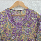 Beige mustard cotton 3-piece churidar set with lavender floral block print, gold V-neckline detail, ivory dupatta and matching printed bottom.