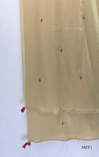 Warm beige cotton 3-piece churidar set with pink and mustard ikat-style print, mirror-trimmed V-neck, plain beige bottom and matching dupatta.