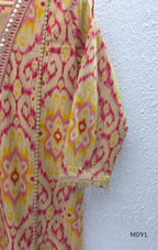Warm beige cotton 3-piece churidar set with pink and mustard ikat-style print, mirror-trimmed V-neck, plain beige bottom and matching dupatta.