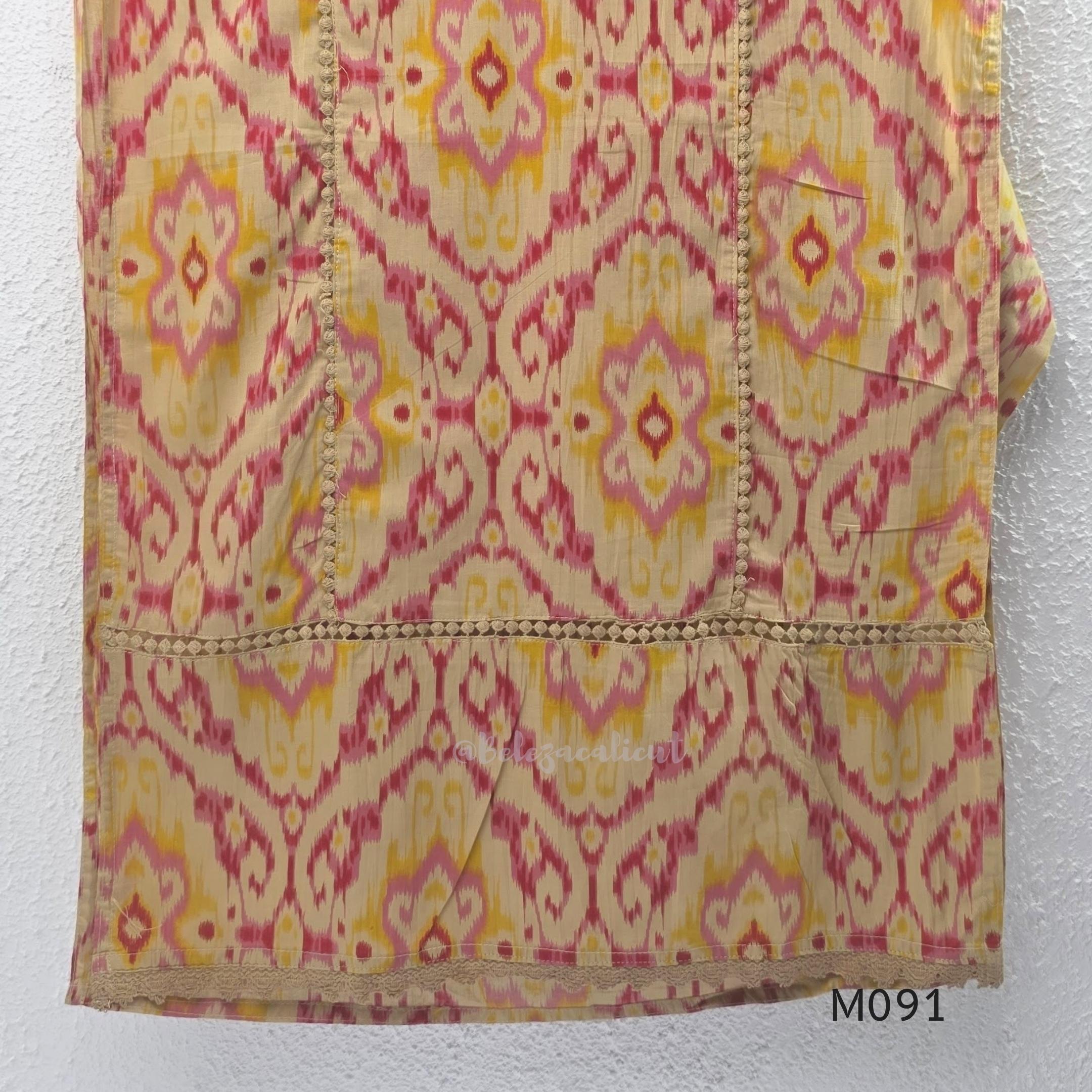Warm beige cotton 3-piece churidar set with pink and mustard ikat-style print, mirror-trimmed V-neck, plain beige bottom and matching dupatta.