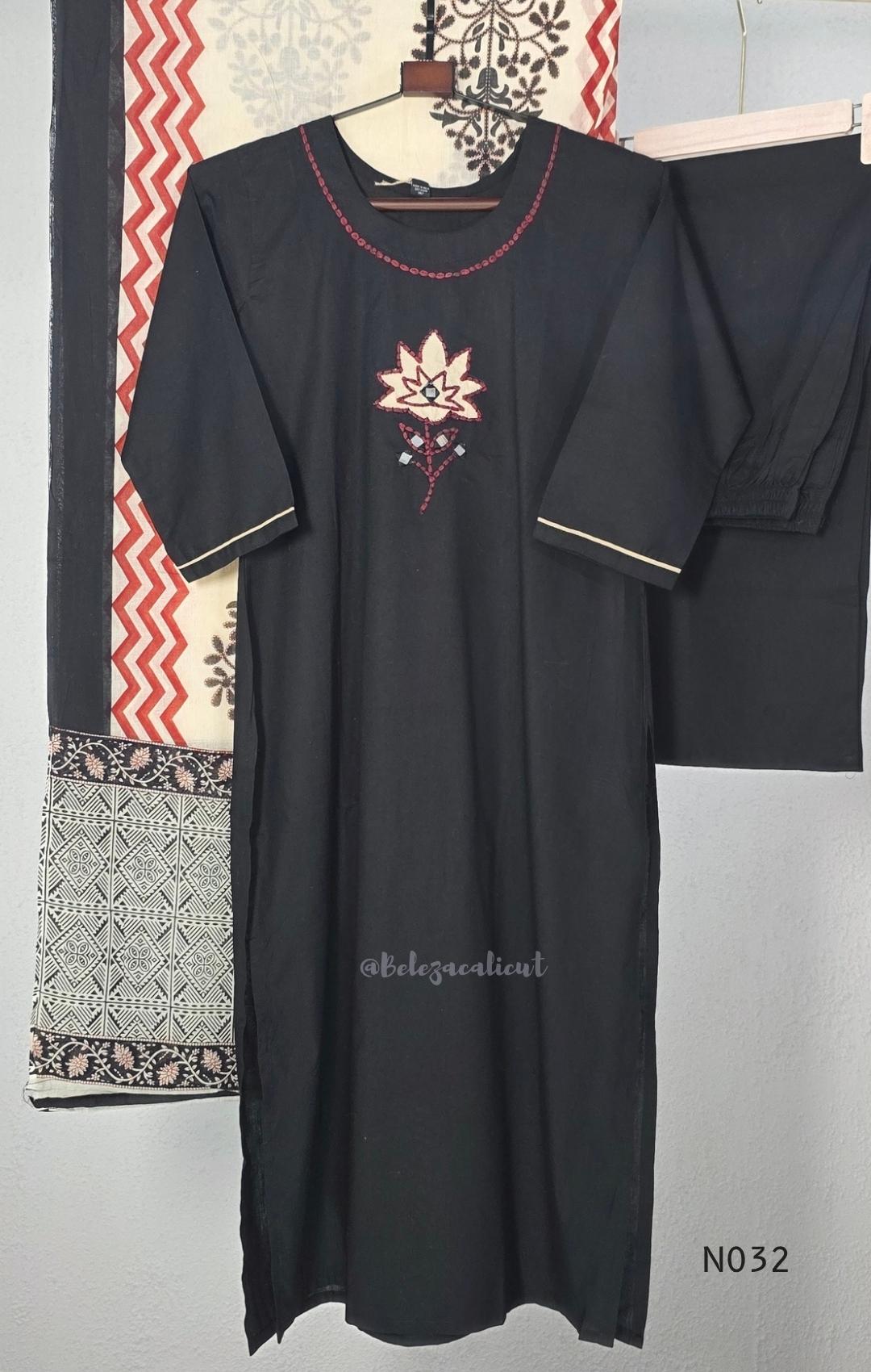 Black cotton three-piece churidar set with a cream floral appliqué, red embroidery, mirror details, black palazzo pants and a cream printed dupatta.