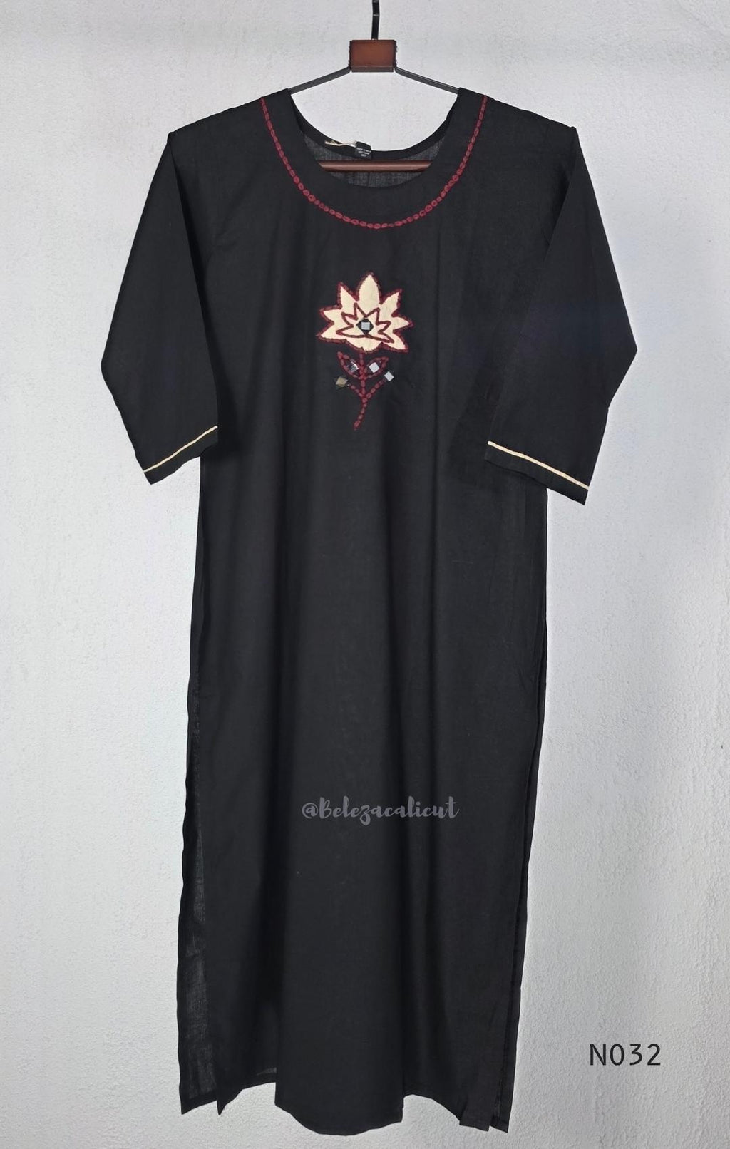 Black cotton three-piece churidar set with a cream floral appliqué, red embroidery, mirror details, black palazzo pants and a cream printed dupatta.