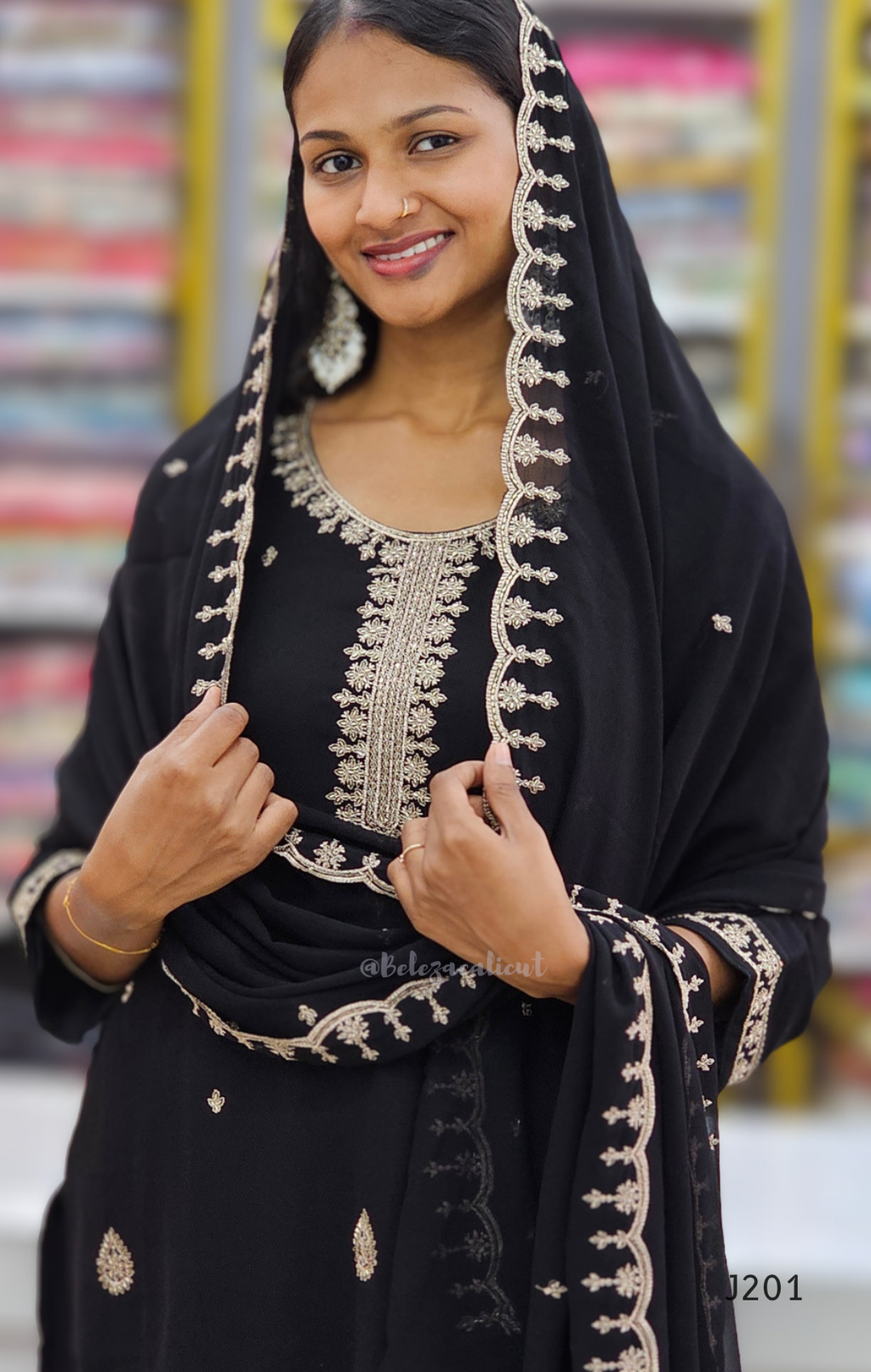 Woman wearing a black embroidered outfit with a colorful background