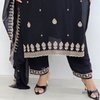Black traditional outfit with gold embroidery on a white background