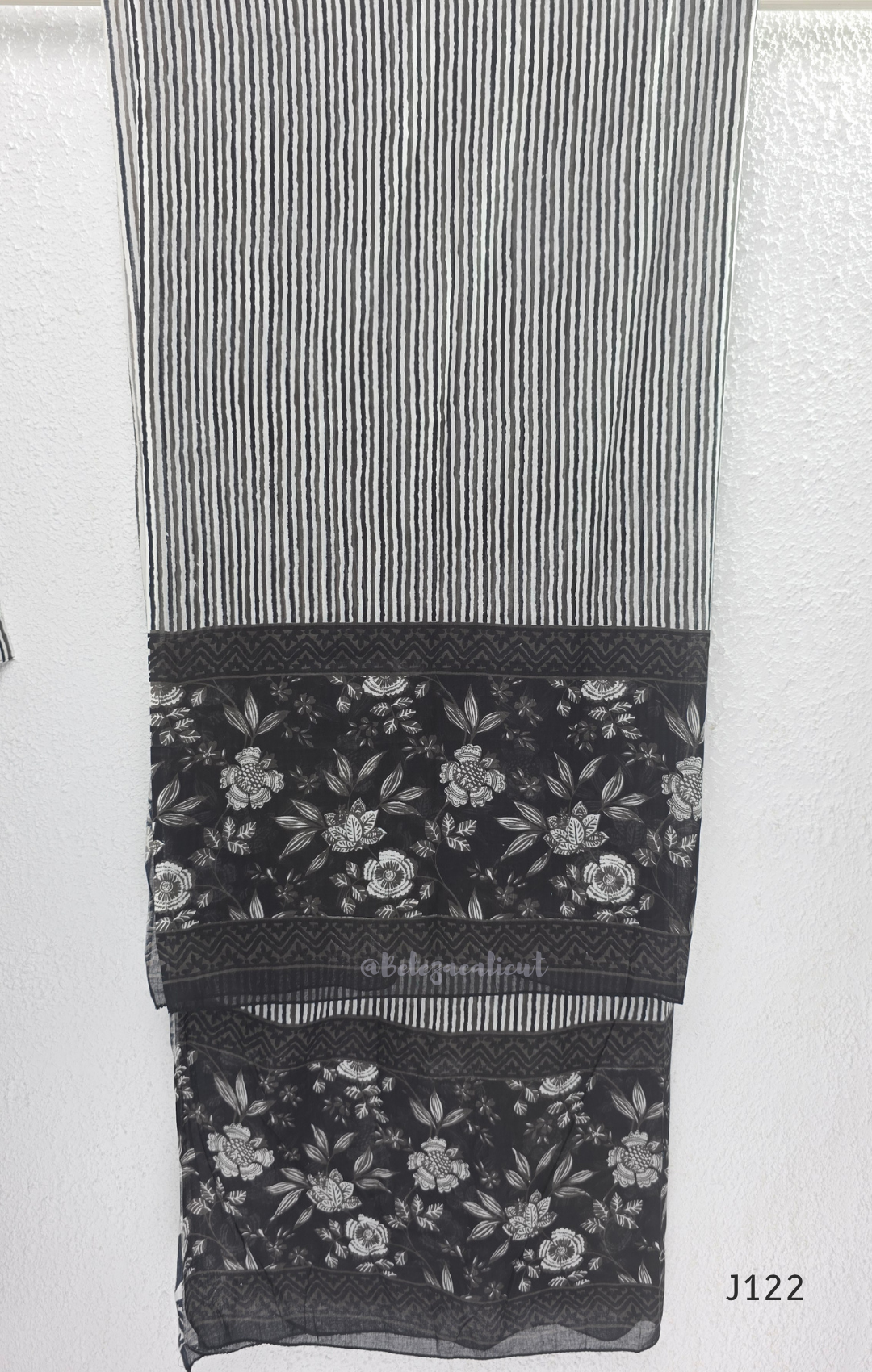 Black Jaipur cotton 3-piece churidar set with grey-white floral print, V-neck detail, printed dupatta and striped matching bottom.