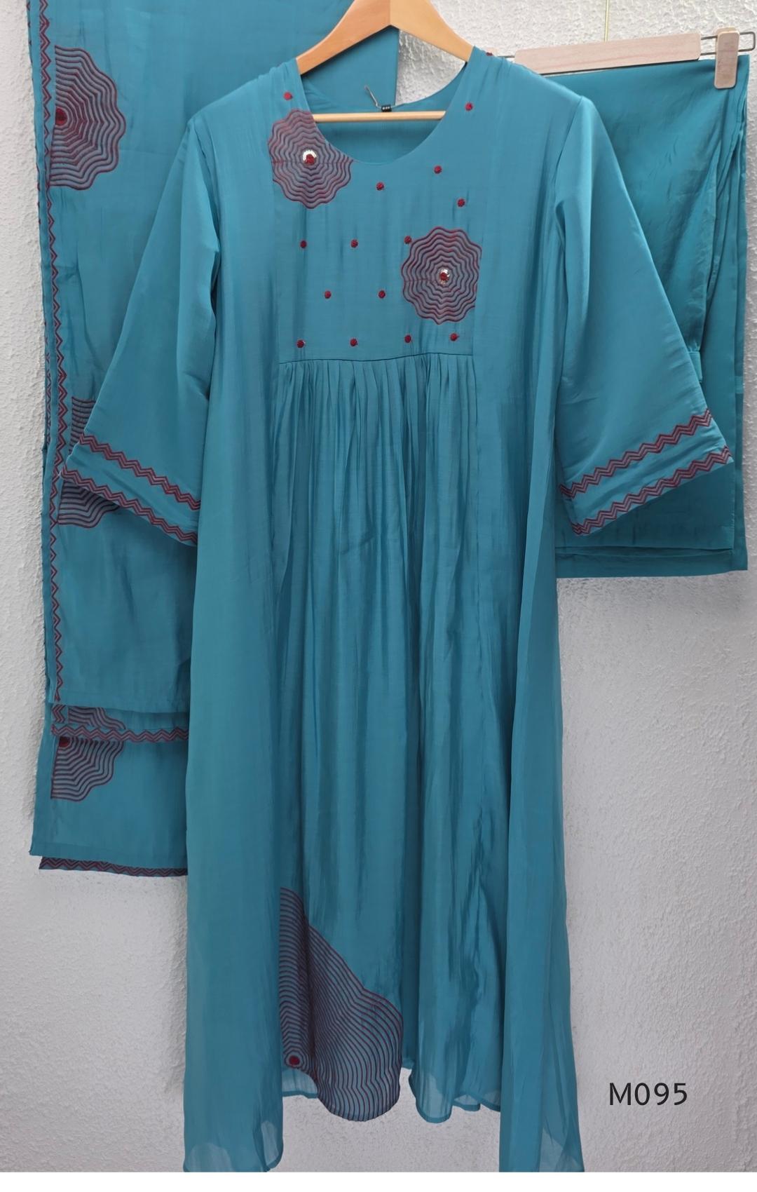 Black and teal blue Mul Chanderi 3-piece churidar sets with red circular embroidery and coordinated dupattas.