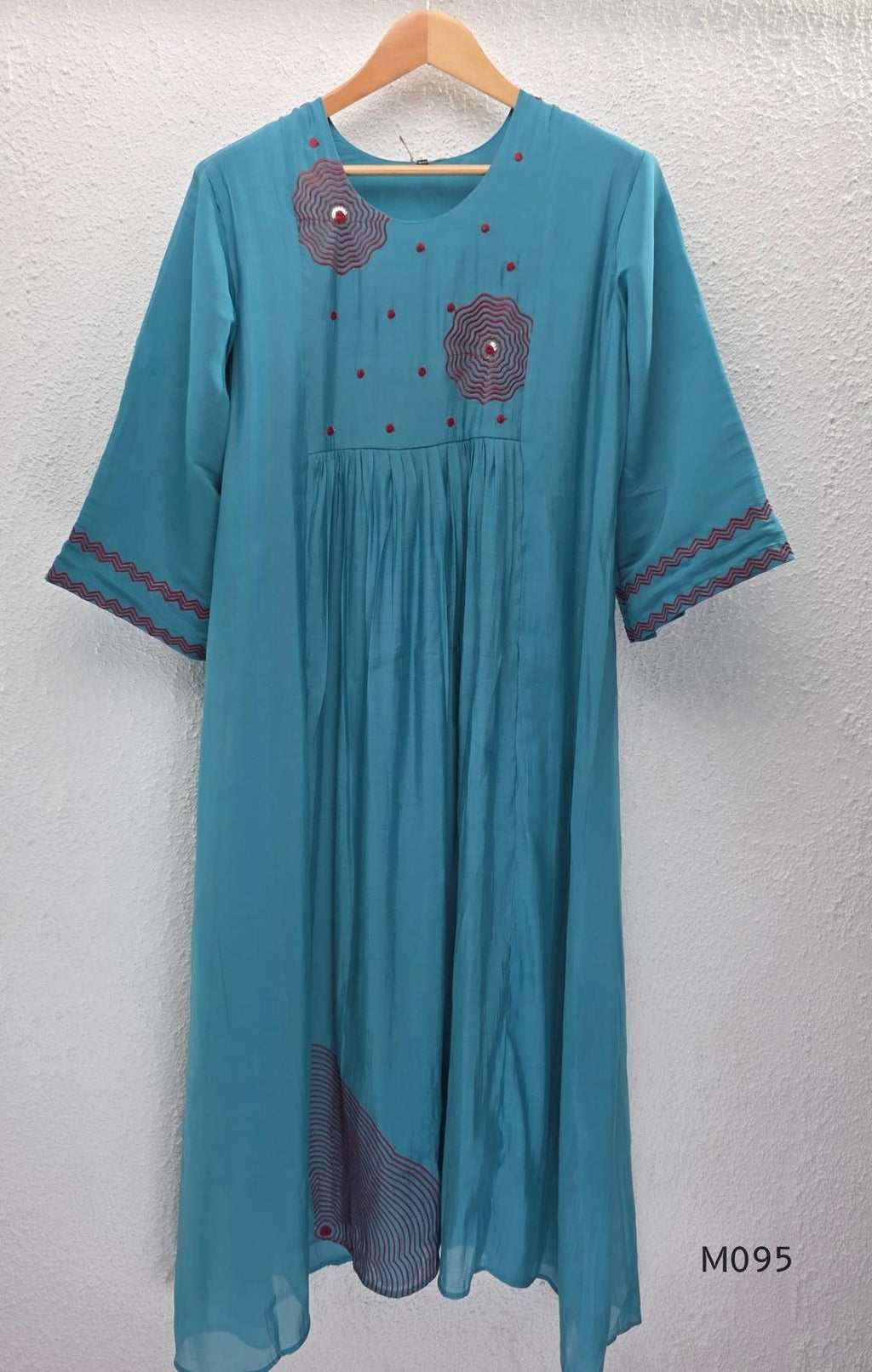 Black and teal blue Mul Chanderi 3-piece churidar sets with red circular embroidery and coordinated dupattas.