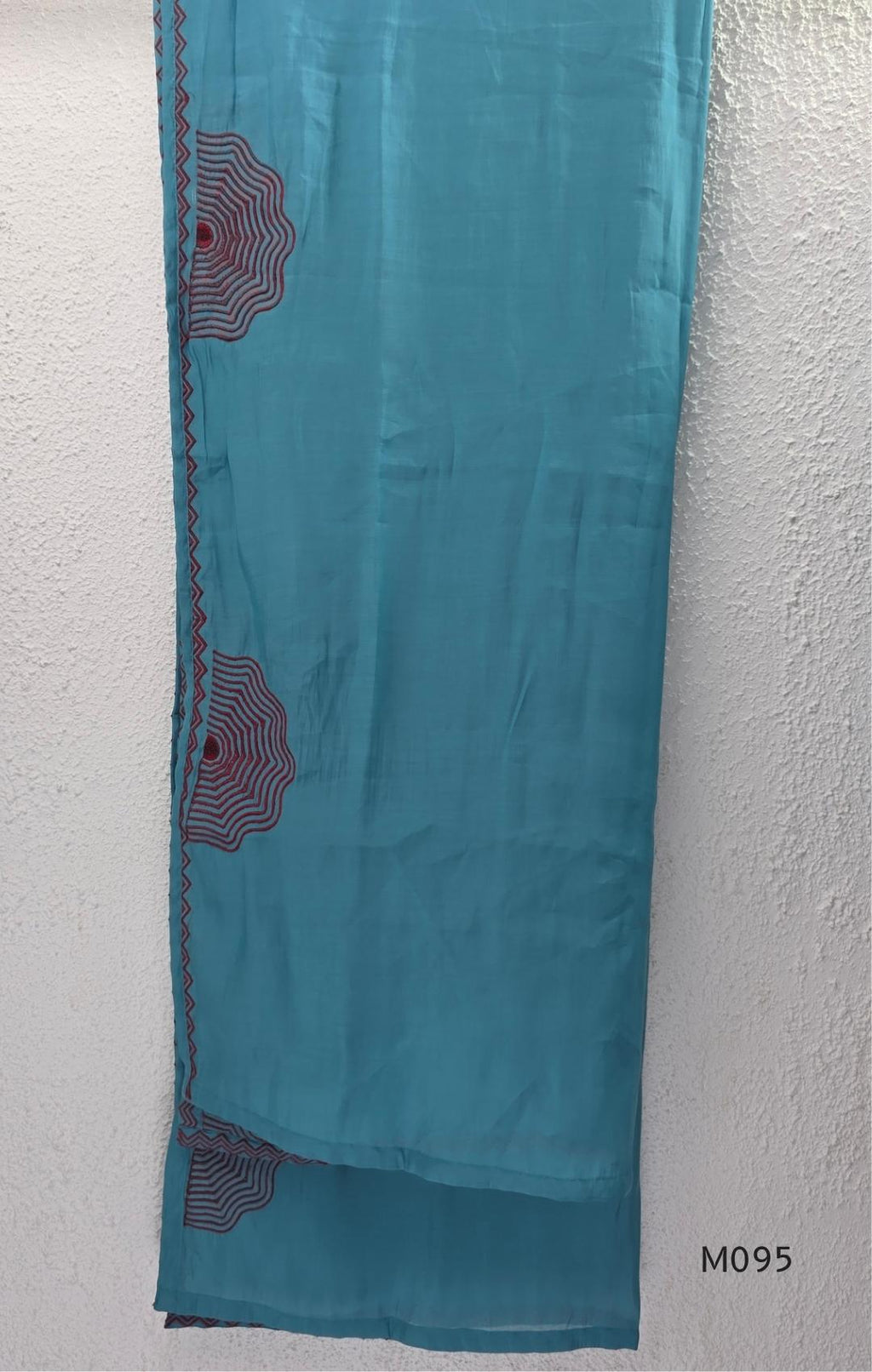 Black and teal blue Mul Chanderi 3-piece churidar sets with red circular embroidery and coordinated dupattas.