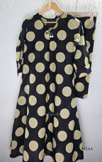 Black cotton co-ord set with muted beige dotted-circle print, A-line mid-calf top and matching tapered pants.