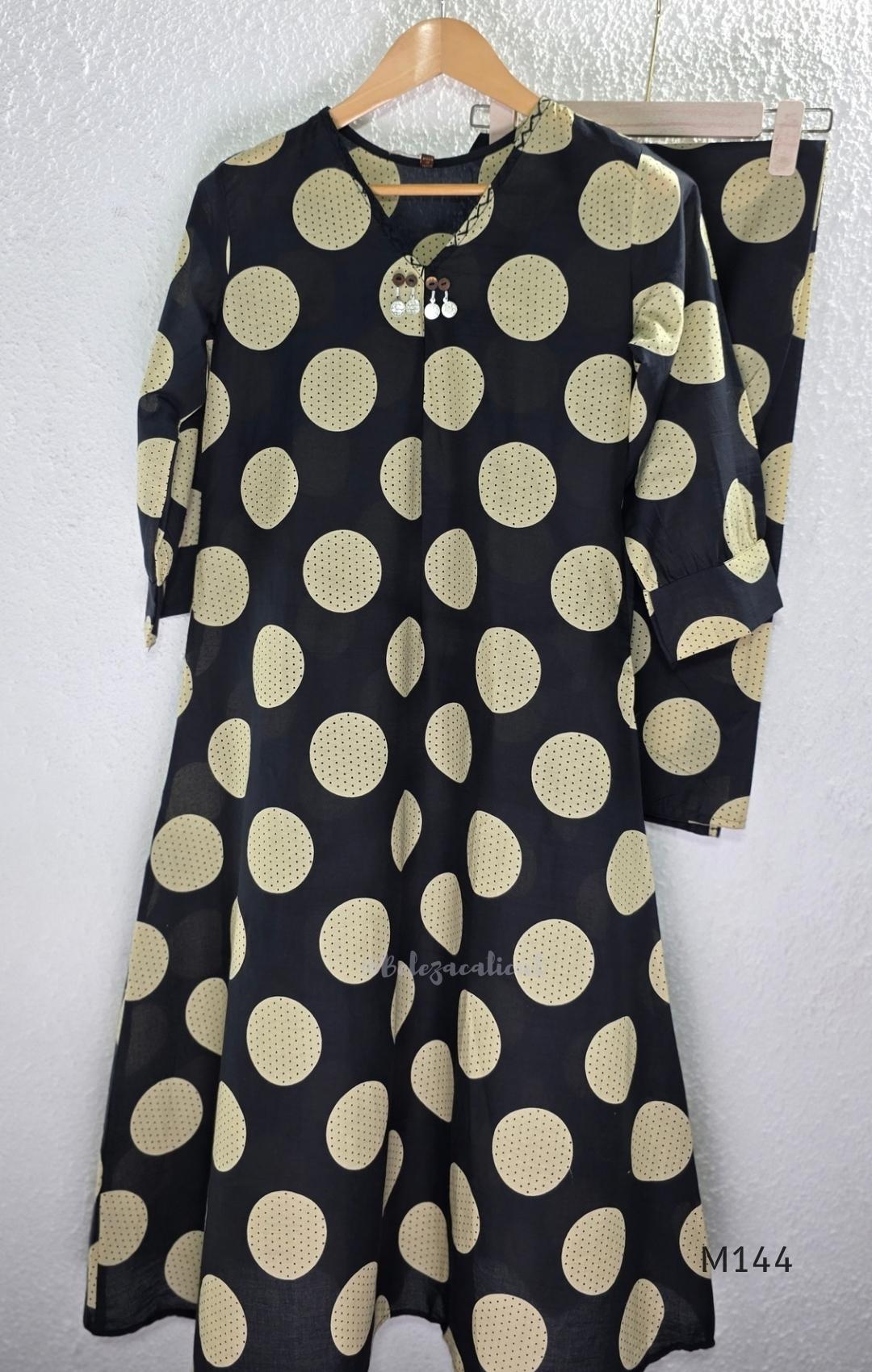 Black cotton co-ord set with muted beige dotted-circle print, A-line mid-calf top and matching tapered pants.