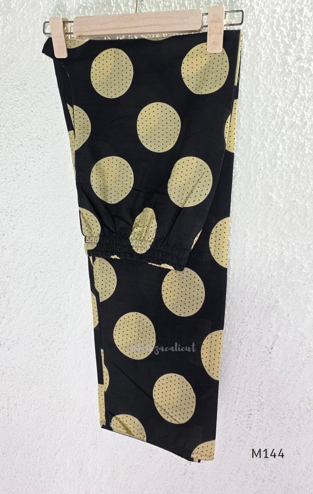 Black cotton co-ord set with muted beige dotted-circle print, A-line mid-calf top and matching tapered pants.