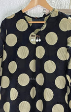 Black cotton co-ord set with muted beige dotted-circle print, A-line mid-calf top and matching tapered pants.