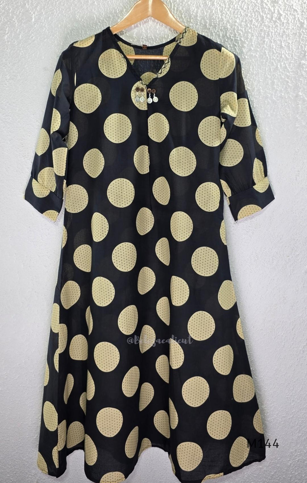 Black cotton co-ord set with muted beige dotted-circle print, A-line mid-calf top and matching tapered pants.