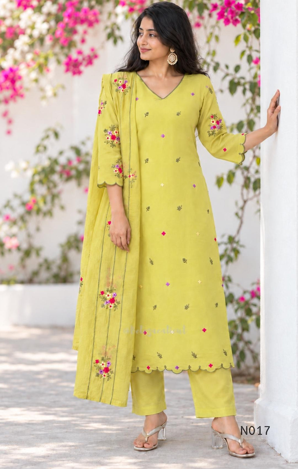 yellow Mul Chanderi three-piece churidar sets with floral embroidery, scalloped kurta hems and cuffs, plain pants and matching dupattas.