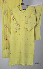 yellow Mul Chanderi three-piece churidar sets with floral embroidery, scalloped kurta hems and cuffs, plain pants and matching dupattas.