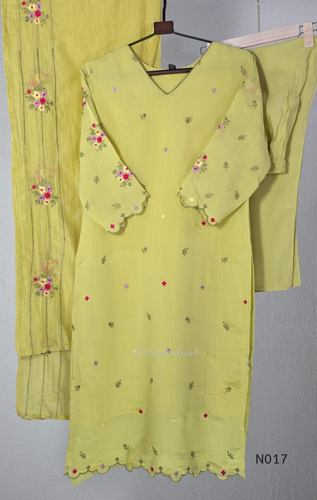 yellow Mul Chanderi three-piece churidar sets with floral embroidery, scalloped kurta hems and cuffs, plain pants and matching dupattas.