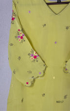 yellow Mul Chanderi three-piece churidar sets with floral embroidery, scalloped kurta hems and cuffs, plain pants and matching dupattas.