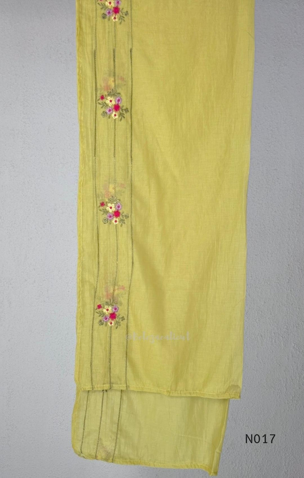 yellow Mul Chanderi three-piece churidar sets with floral embroidery, scalloped kurta hems and cuffs, plain pants and matching dupattas.