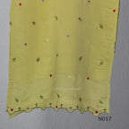 yellow Mul Chanderi three-piece churidar sets with floral embroidery, scalloped kurta hems and cuffs, plain pants and matching dupattas.