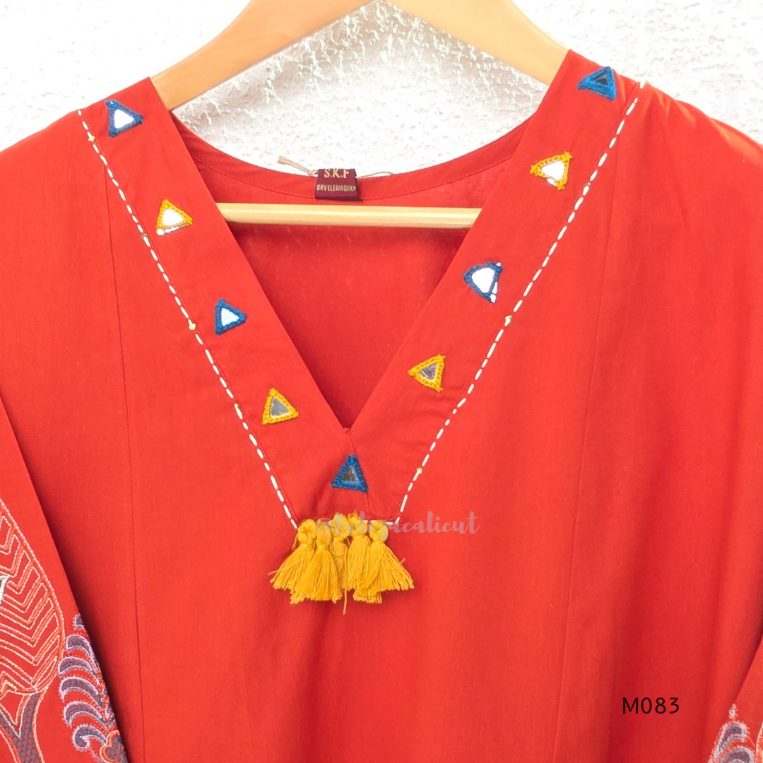 Bright orange cotton plus size churidar set with tassel V-neck, embroidered sleeve detail, matching bottom and dupatta.